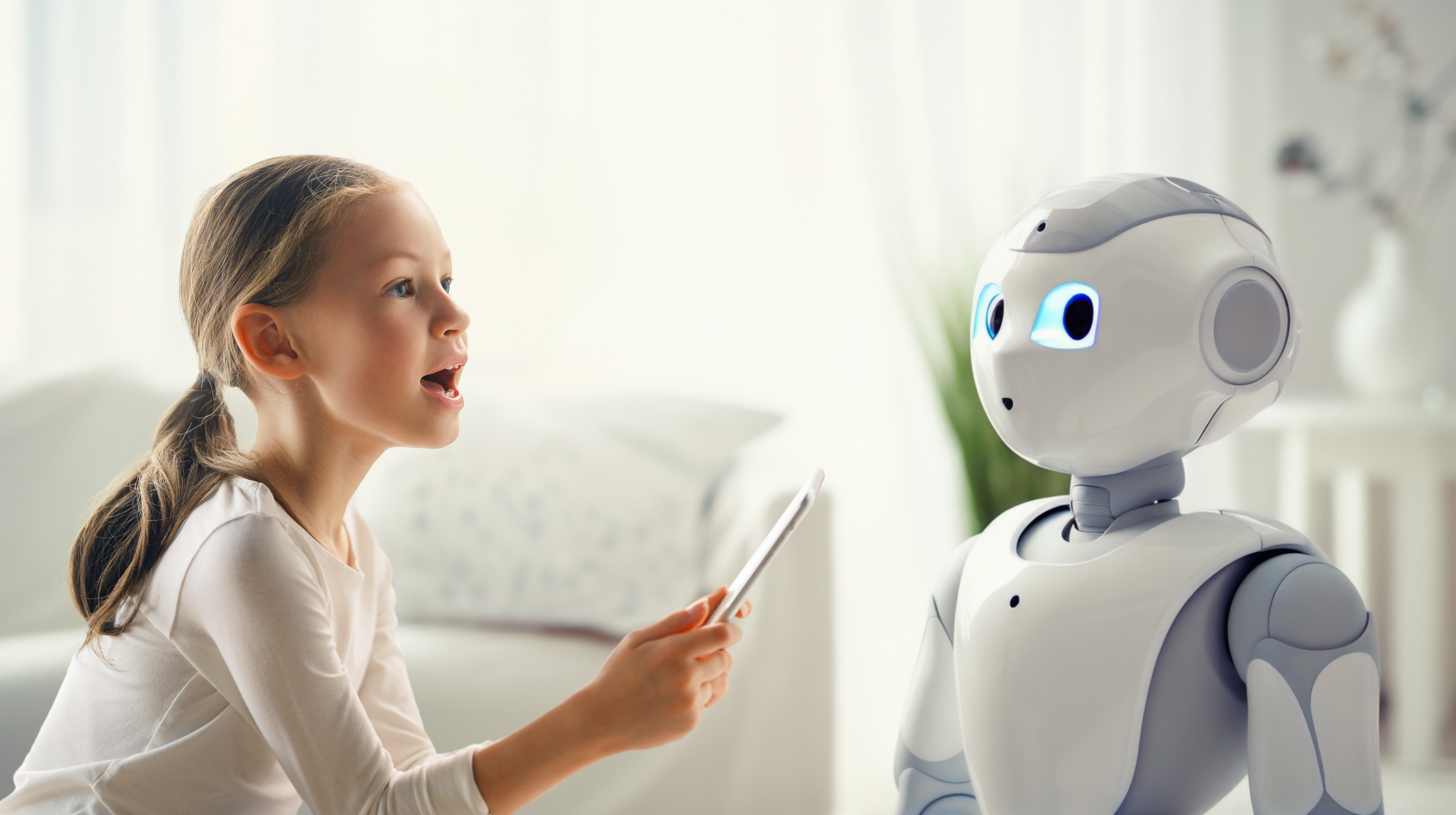 Ein blondes Mädchen spricht mit einem Roboter